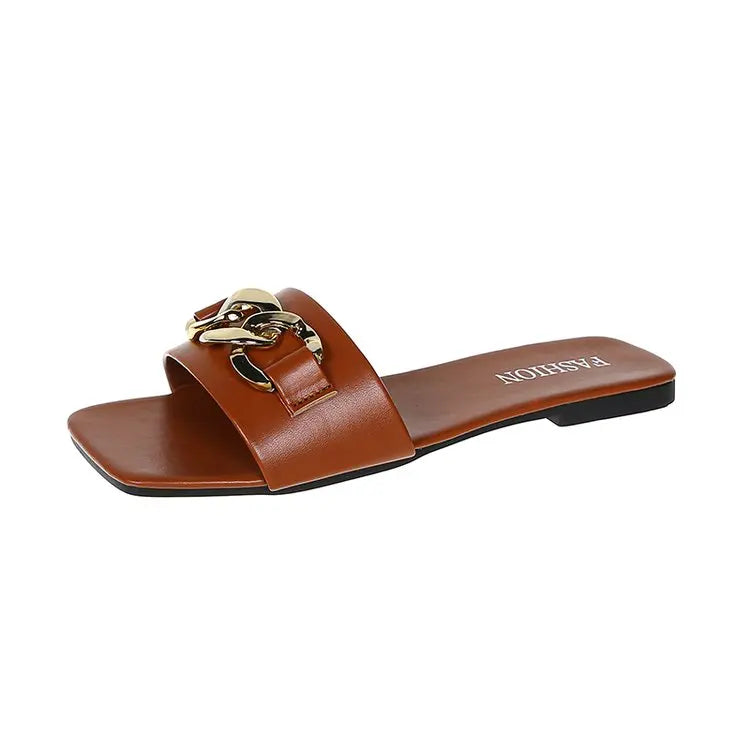 Flade damesandaler med dekorativ metalkæde og slip-on design – Solvéra