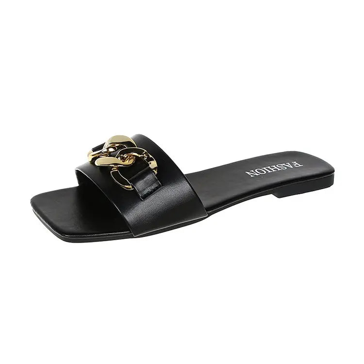 Flade damesandaler med dekorativ metalkæde og slip-on design – Solvéra